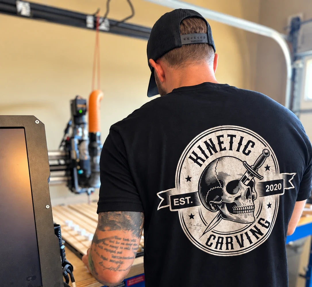Kinetic Carving founder at his CNC machine, wearing the Kinetic Carving skull shirt